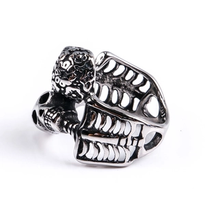 Detail of punk style double skull ring with hollow rib cage band in antique silver finish