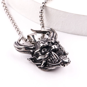 Macro side view of retro devil mask pendant with sharp horns and fangs in vintage silver