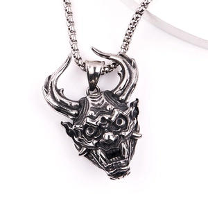 Macro shot of retro stainless steel Hannya devil mask pendant with punk relief details