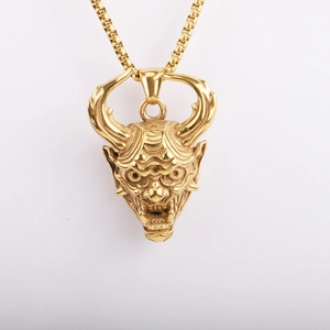 Detailed view of a golden Hannya demon mask pendant with intricate facial textures