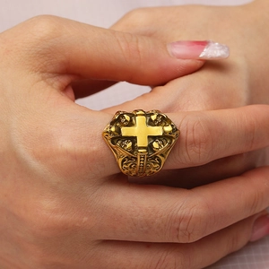 Detailed view of a wide gold gothic ring with cross and skull embossed engravings
