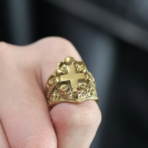 Macro close-up of a gold gothic cross ring with detailed skull relief for men