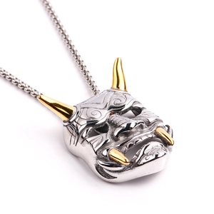 Vue macro détaillée du pendentif masque Hannya bicolore argent et or sur chaîne box