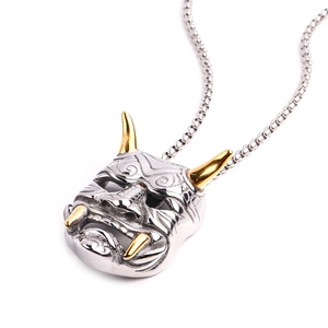 Vue détaillée du pendentif masque Hannya avec cornes dorées et chaîne en acier argent