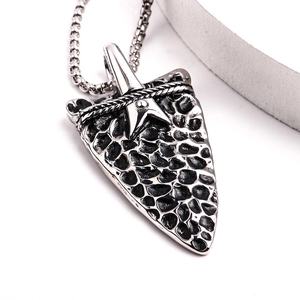 Macro shot of silver arrow pendant with hammered texture and star detail on box chain