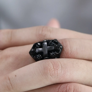 Macro shot of gothic black stainless steel ring featuring cross and skull details on hand