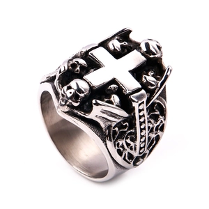 Detail of vintage gothic stainless steel ring with polished cross and skull carvings