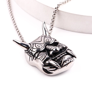Vue macro d'un pendentif masque de démon gothique en acier inoxydable argenté poli