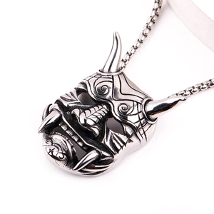 Vue macro du pendentif crâne Hannya punk argenté avec cornes et crocs sur chaîne