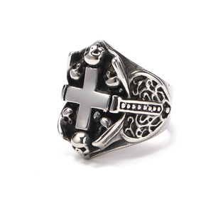Close-up of vintage stainless steel cross ring with 3D skull and gothic relief patterns