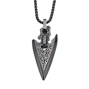 Macro shot of retro arrowhead pendant featuring rugged rock texture and dark steel finish