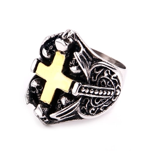 Macro shot of gothic steel ring with golden cross and skull carvings on a white background