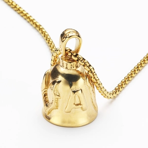 Macro shot of a golden stainless steel eagle wing bell pendant with letter A relief