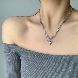 Detail der silbernen Herz-Halskette mit asymmetrischer Kette, am Model elegant präsentiert
