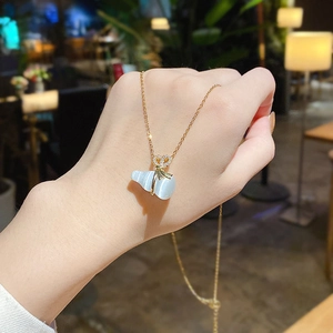 Elegante collana in acciaio al titanio dorato con ciondolo in occhio di gatto e fiocco