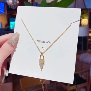 Minimalist gold lock and key pendant necklace with sparkling micro-pave crystals