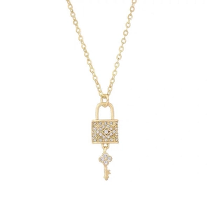 Elegant gold lock and key necklace set with white cubic zirconia pavé on white background