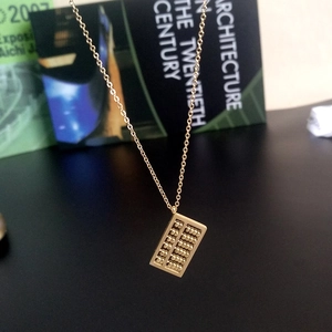 Elegante Halskette mit Abakus-Anhänger in Roségold auf einem Buchhintergrund
