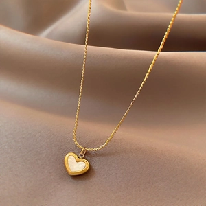 French vintage gold heart necklace with white mother of pearl on silk background
