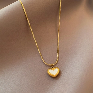 Detail of a vintage heart pendant necklace with white mother of pearl in gold plating