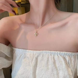 Close-up of a rotating gold windmill necklace with micro-pave zircons on a model's neck