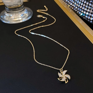 Detailed close-up of a rotating gold windmill pendant with shimmering micro-set zircons