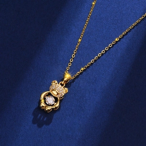 Golden bear necklace with micro-paved zircons and dancing stone on blue background