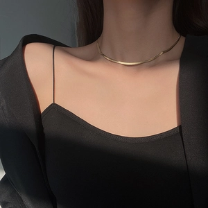 Minimalist gold snake bone necklace in flat herringbone chain style worn by female model