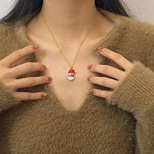 Detail van Kerstman hanger ketting op een bruine trui voor een feestelijke styling