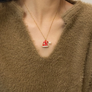 Detail van kerstmuts hanger met rood emaille, gouden sneeuwvlokken en glanzende kristallen