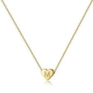 Dettaglio macro del ciondolo a cuore in oro 18 carati con lettera M incisa su catena sottile