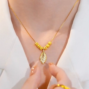 Titanium steel leaf pendant necklace with zircon and gold beads on a female model