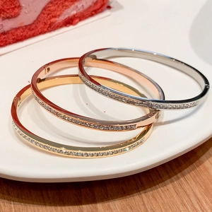 Three rows of titanium steel bangles in gold, rose gold and silver with crystal pavé