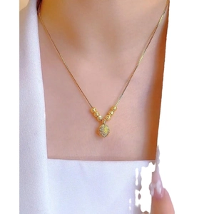 Gold-plated necklace featuring frosted texture pendant and round golden beads on model