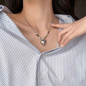 Collana a cuore in acciaio al titanio lucido con perline cubiche su modella