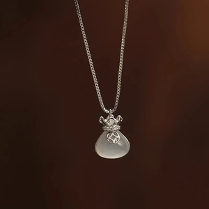 Detail van de zilveren gelukszak-hanger ketting met witte chalcedoon steen afwerking