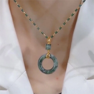 Luxurious gold necklace featuring a gradient green jade Ping'an buckle pendant on a model