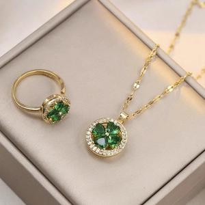 Titanium steel jewelry set featuring emerald green clover pendant and rotating ring with zircons