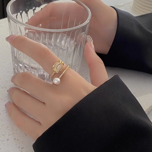 Elegant gold tulip ring with a white pearl and sparkling crystals in an open design