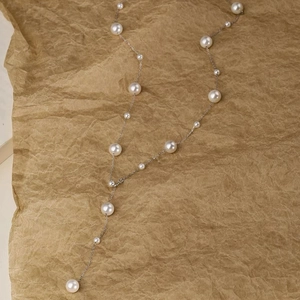 Detailopname van de elegante Y-vormige parelketting met een fijne zilveren ketting