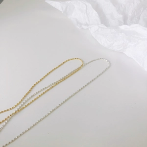 Minimalistische Halsketten aus Titanstahl mit ovalen Perlen in Gold und Silber auf Weiß