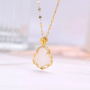 Macro shot of gold-plated pendant with white jade gourd and micro-inlaid diamonds
