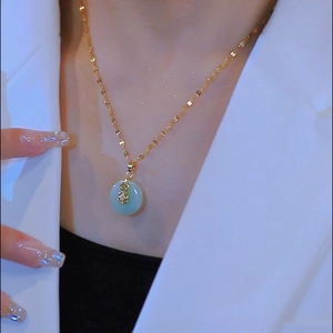 Elegante collana d'oro con pendente in giada verde e ciondolo a zucca con diamanti su modella