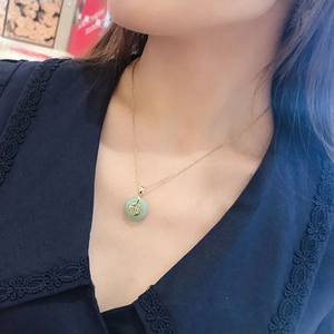 Collier en chaîne dorée avec pendentif cercle en jade vert et symbole Fu central