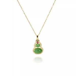 Detailed view of a gold gourd pendant necklace with green stones and sparkling zircon accents