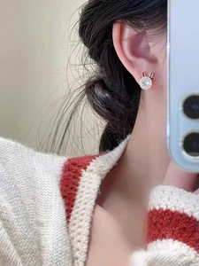 Macro shot of creative rabbit stud earring with white zircon and golden ear details