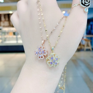 Rotating purple clover pendant necklaces in gold and rose gold with sparkling crystals