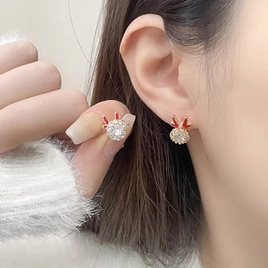 Close-up of golden rotating dragon earrings with zircon inlay and red enamel detailing