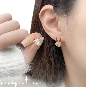 Detail of a rotating golden earring with red bunny ears and pavé crystal ball on a model