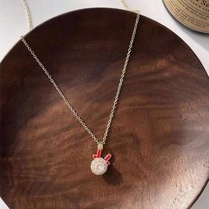 Detail of gold necklace featuring a bunny ear pendant with a sparkling crystal center
